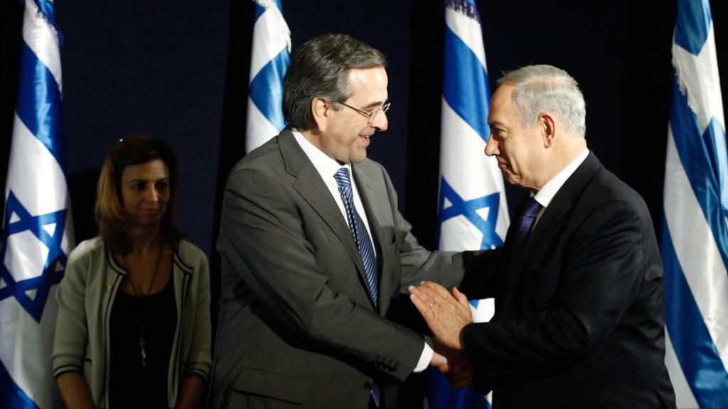 PM Samaras shakes hands happily with the evil King of the Jews.