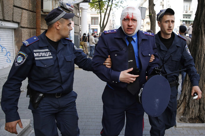 Ukrainian police help an injured colleague during clashes between pro-Russian activists and supporters of the Kiev government in the streets of Odessa