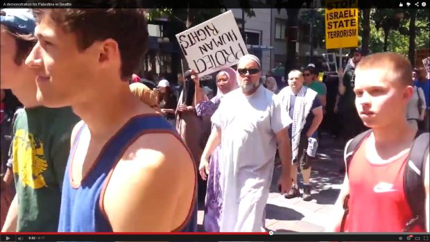 She's holding the sign upside down. Because Arab immigrants to the US don't need to read English, or even have any idea what the letters look like in a general sense.