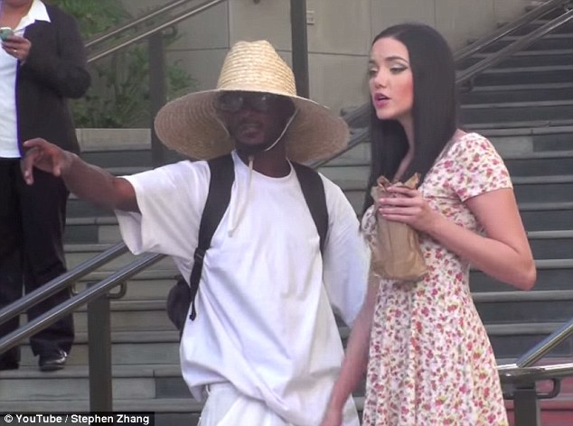 In the fake video, the only man who doesn't attempt to sex the woman is a Black man in a sun hat.