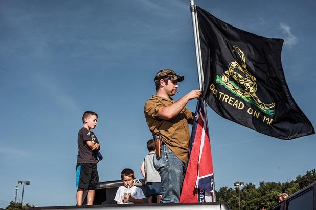 Ira Pierce erects his flags on the back of his truck during a confederate flag rally held in a parking lot in Seymour, Tennessee on Thursday, July 17, 2015. Host Tom Pierce, and guest, Mathew Heimbach delivered speeches before prompting the group to drive with flags raised through Knoxville. Mike Belleme for Al Jazeera America Ira Pierce erects his flags on the back of his truck during a confederate flag rally held in a parking lot in Seymour, Tennessee on Thursday, July 17, 2015. Host Tom Pierce, and guest, Mathew Heimbach delivered speeches before prompting the group to drive with flags raised through Knoxville. Mike Belleme for Al Jazeera America