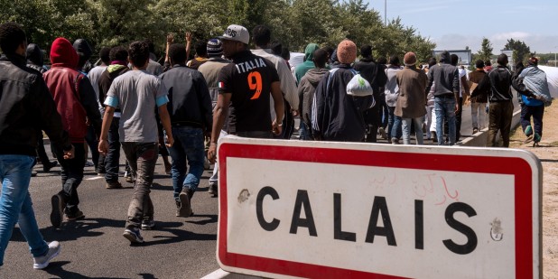 Migrants walk on June 17, 2015 towards the ferry port of Calais, northern France. Around 3,000 migrants built makeshift shelters in the so-called 'New Jungle' before trying to go to England. AFP PHOTO / PHILIPPE HUGUEN (Photo credit should read PHILIPPE HUGUEN/AFP/Getty Images)