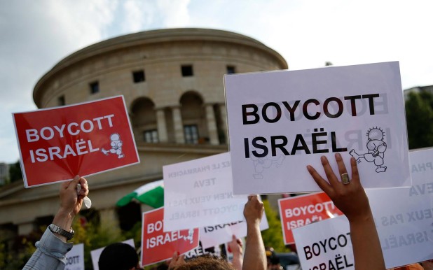 epa04336864 Protesters hold up placards reading 'Boycott Israel' during a demonstration showing solidarity with Palestinians in the context of the Palestinian-Israeli conflict, in Paris, France, 31 July 2014. The death toll in the Gaza Strip after more than three weeks of airstrikes and shelling has topped 1,400, Gaza Health Ministry spokesman Ashraf al-Qedra said on 31 July. EPA/CHRISTOPHE KARABA