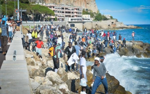 104967265_Migrants_stand_on_the_rocks_FOREIGN-large_trans++aRL1kC4G7DT9ZsZm6Pe3PehAFAI_f6ud569StXyOKH0