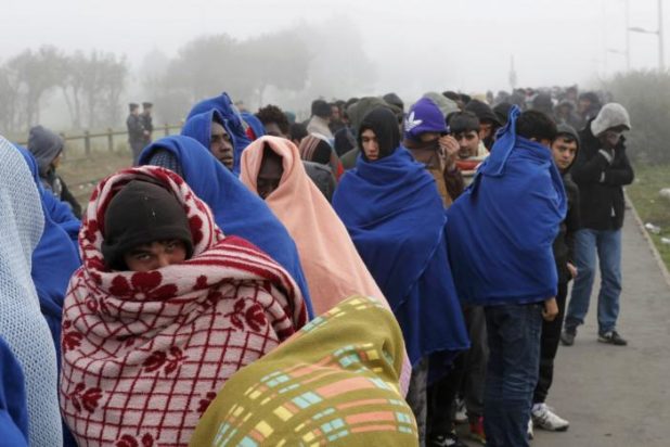 Migrants queue on the third day of their evacuation and transfer to reception centers in France, as part of the dismantlement of the camp called the "Jungle" in Calais