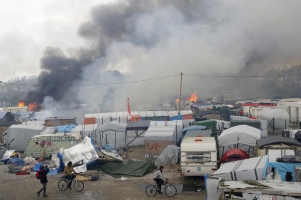 Smoke rises the sky as makeshift shelters and tents burn in the "Jungle" on the third day of the evacuation of migrants as part of the dismantlement of the camp called the "Jungle" in Calais