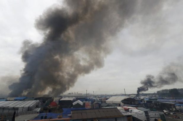 Smoke rises the sky as makeshift shelters and tents burn in the "Jungle" on the third day of the evacuation of migrants as part of the dismantlement of the camp called the "Jungle" in Calais